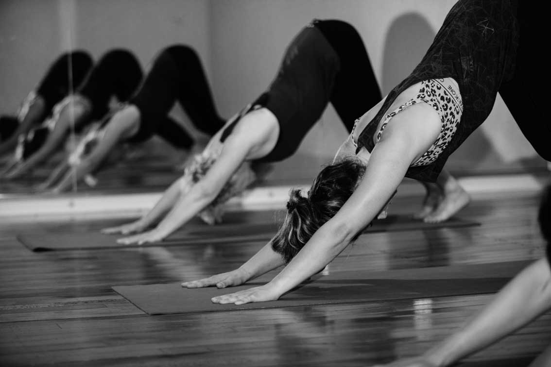 yoga class doing downward dog pose